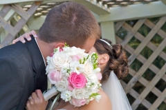 Bride-Groom-Kissing-Flowers-Outdoors