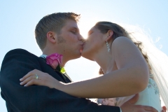 Groom-Bride-Kissing-Outdoors-Sunlight