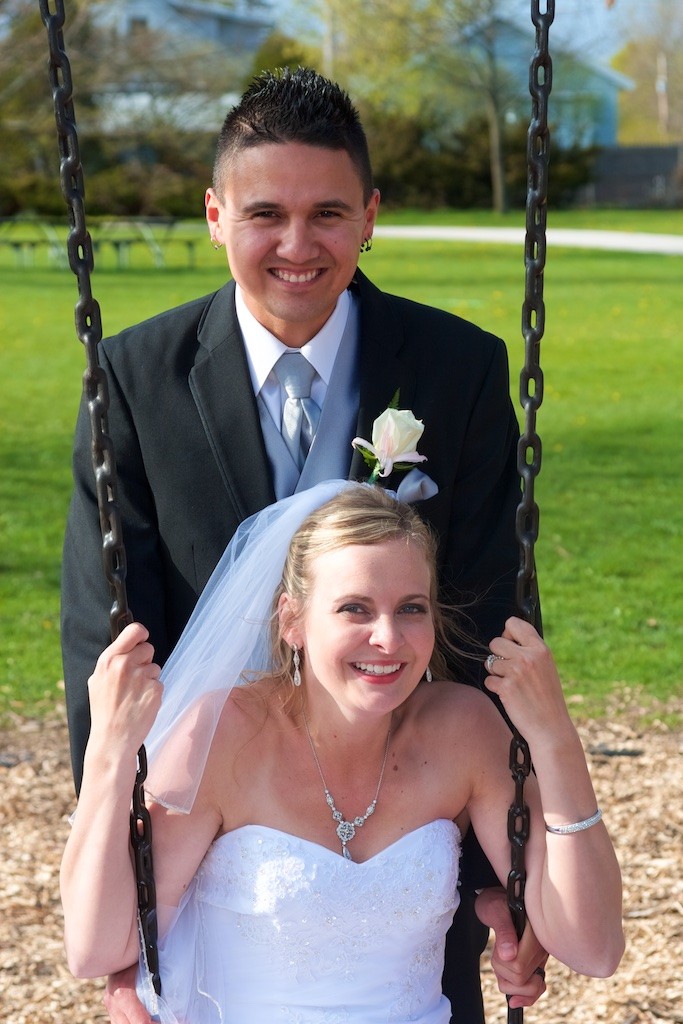 Groom and Bride in a Park on the Swings for their wedding day portraits